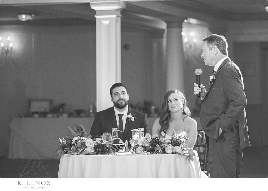 Black and White photo of a father giving a toast to the bride and groom at the mountain view grand in Whitefield NH> 