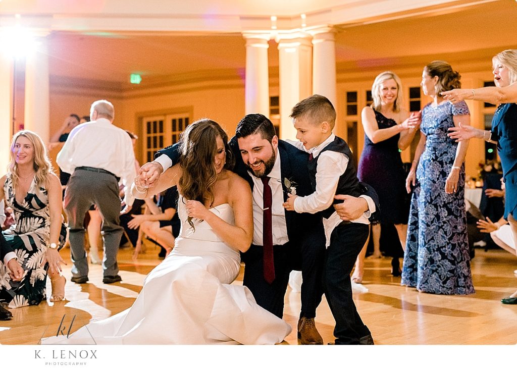 Candid photo taken of the bride and groom dancing with their nephew at the Mountain View Grand's Crystal Ballroom Reception. 