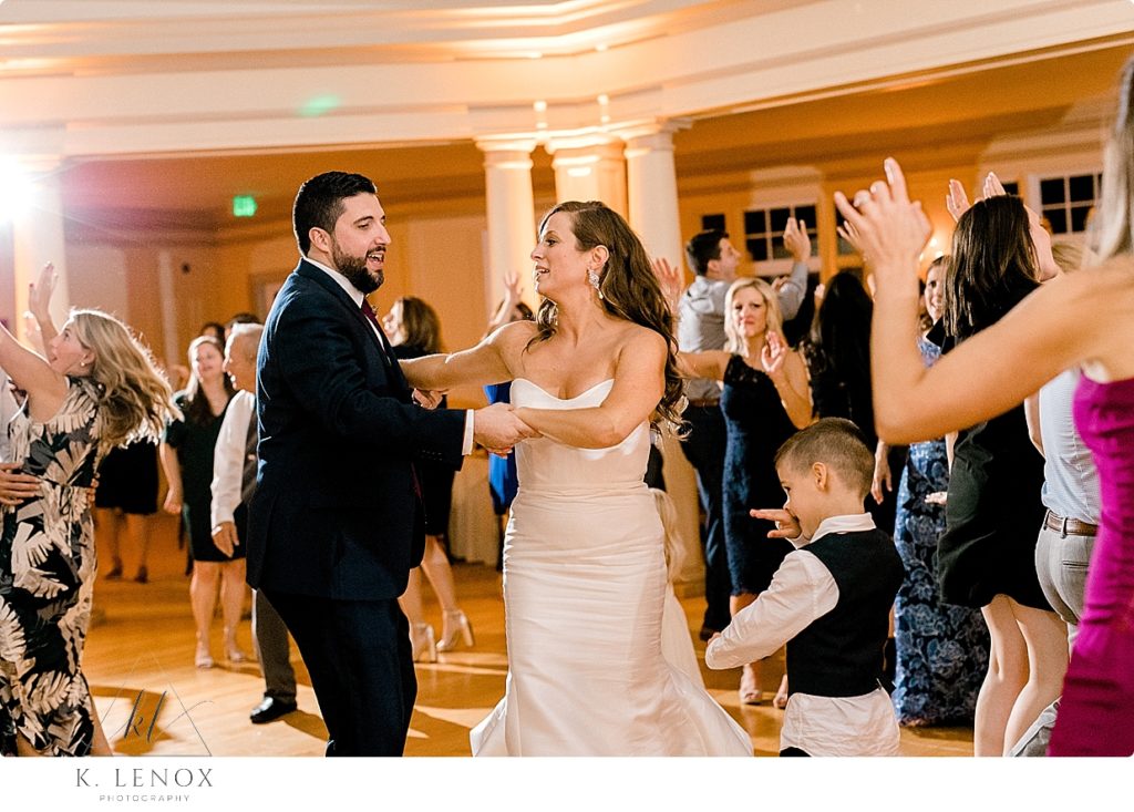 Candid photo of the bride and groom dancing during their wedding reception. 