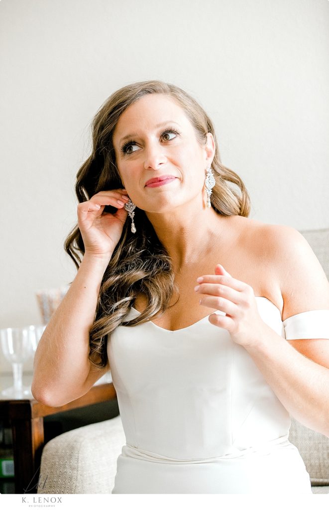 Bride puts on her diamond dangly earrings for her fall wedding at the Mountain View Grand
