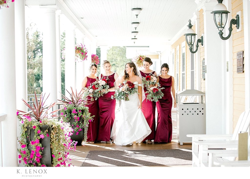 Bride and Bridesmaids wearing maroon dresses on the porch of the Mountain View Grand for their Fall wedding. 