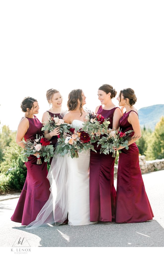 A Bride and her Bridesmaids pose for a portrait for their Fall Wedding at the Mountain View Grand. Bridesmaids wearing simple maroon gowns. 