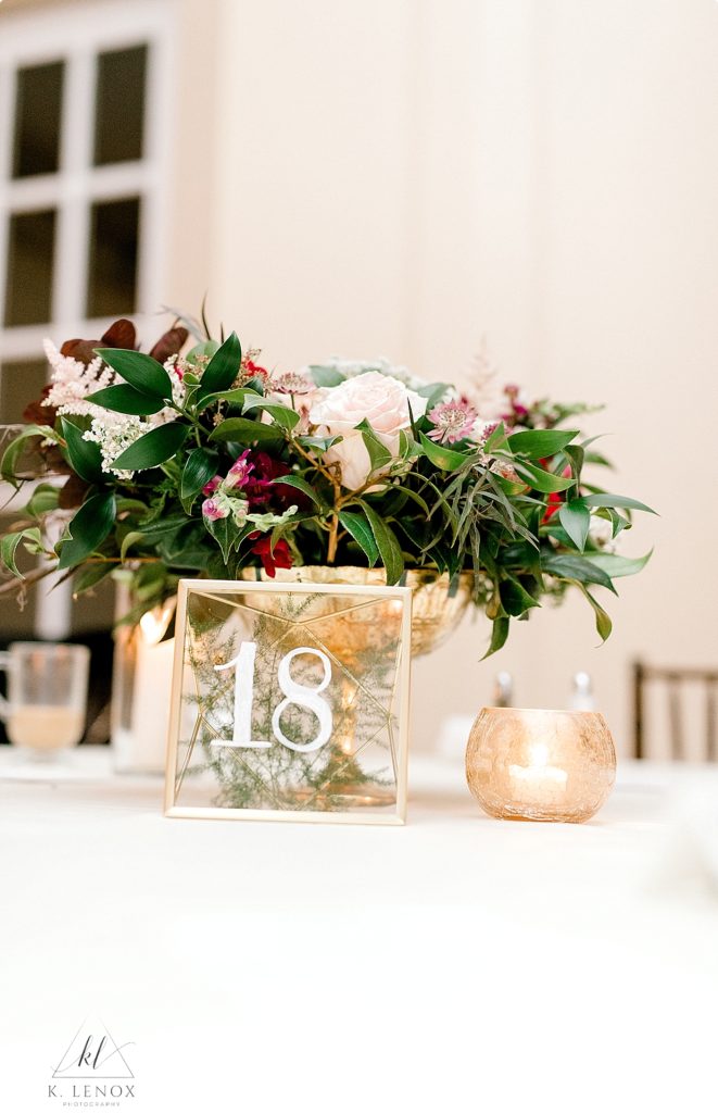 Wedding at the Mountain view Grand- Reception centerpiece with gold containers and gold framed table numbers. 
