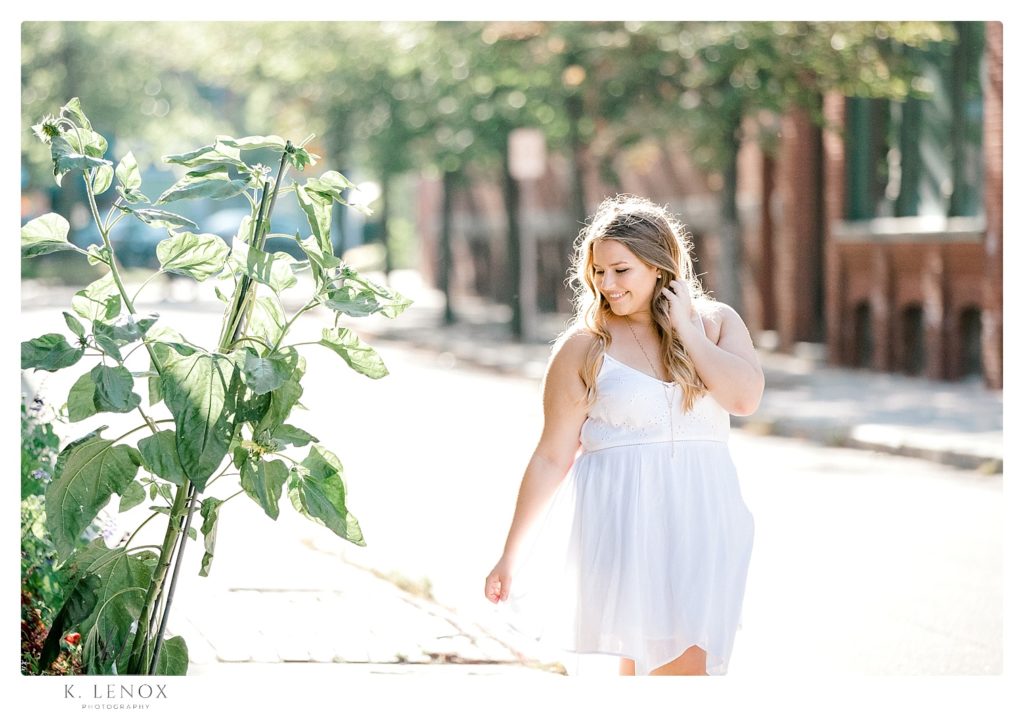 Light and Airy senior photo of a girl wearing a white summer dress. 