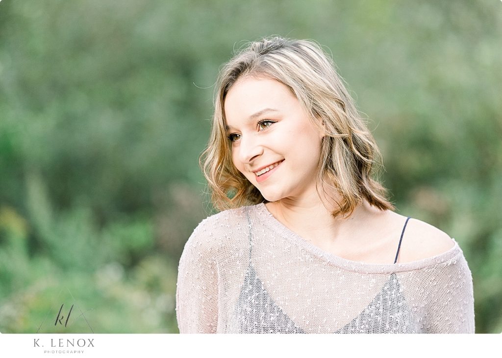 Light and Airy Senior Photo taken of a beautiful girl with short hair- wearing a sheer sweater. 