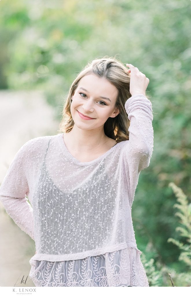 Light and Airy Senior Photo of a girl wearing a sheer sweater at Stonewall Farm. 