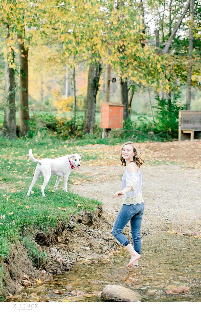 Candid photo of a teenage girl walking towards her dog. 
