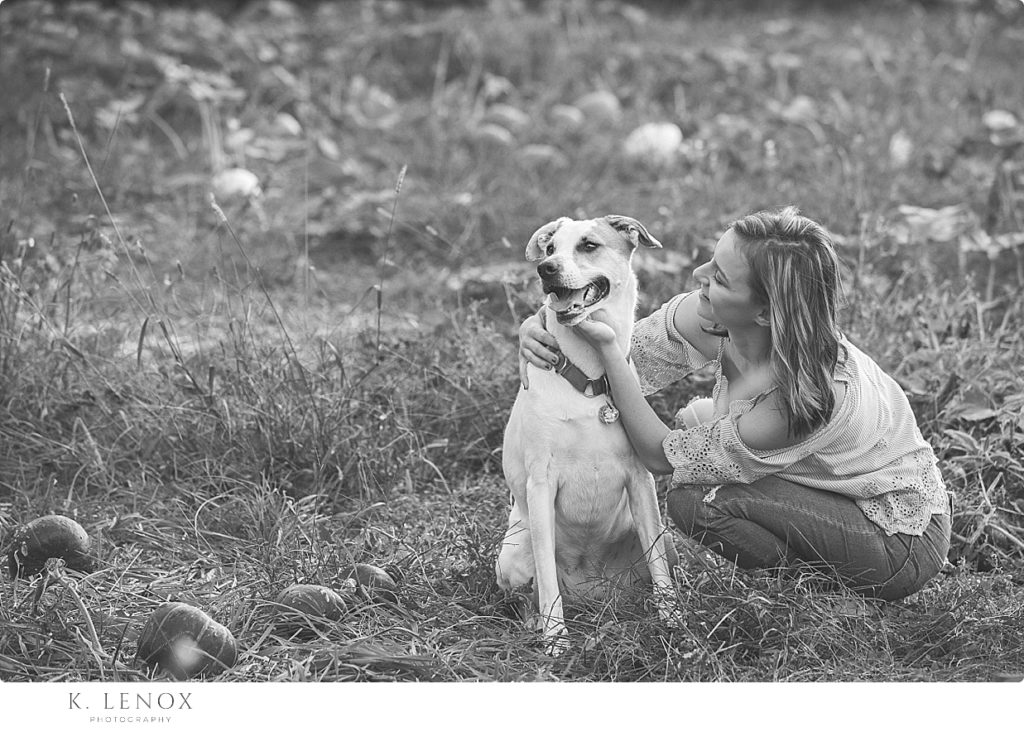 Black and white photo of a girl and her white dog. 