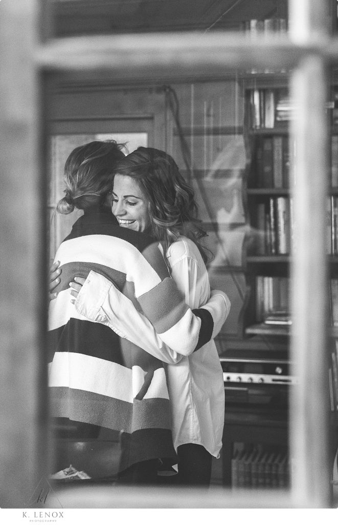 Black and White candid photo taken of a bride and her friend sharing a emotional moment as they get ready for the wedding day. 