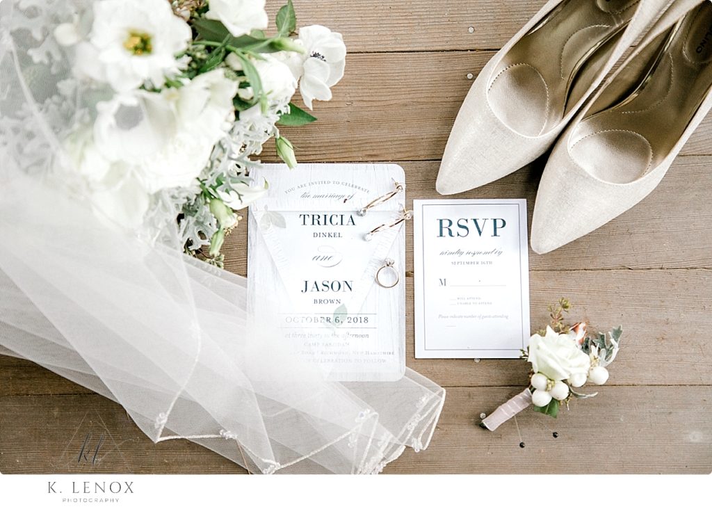 White simple invitation suite shown with the white wedding shoes, bridal bouquet, and veil and boutonniere. Rustic Wedding Photo. 