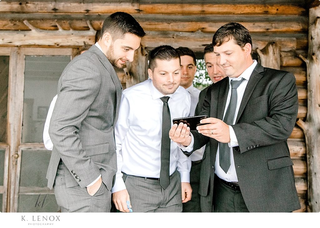 Groomsmen watch a video on putting on boutonnieres before the Wedding at Camp Takodah 