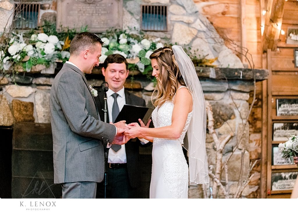 Groom puts the ring on his bride during the rustic wedding ceremony at Camp Takodah. 