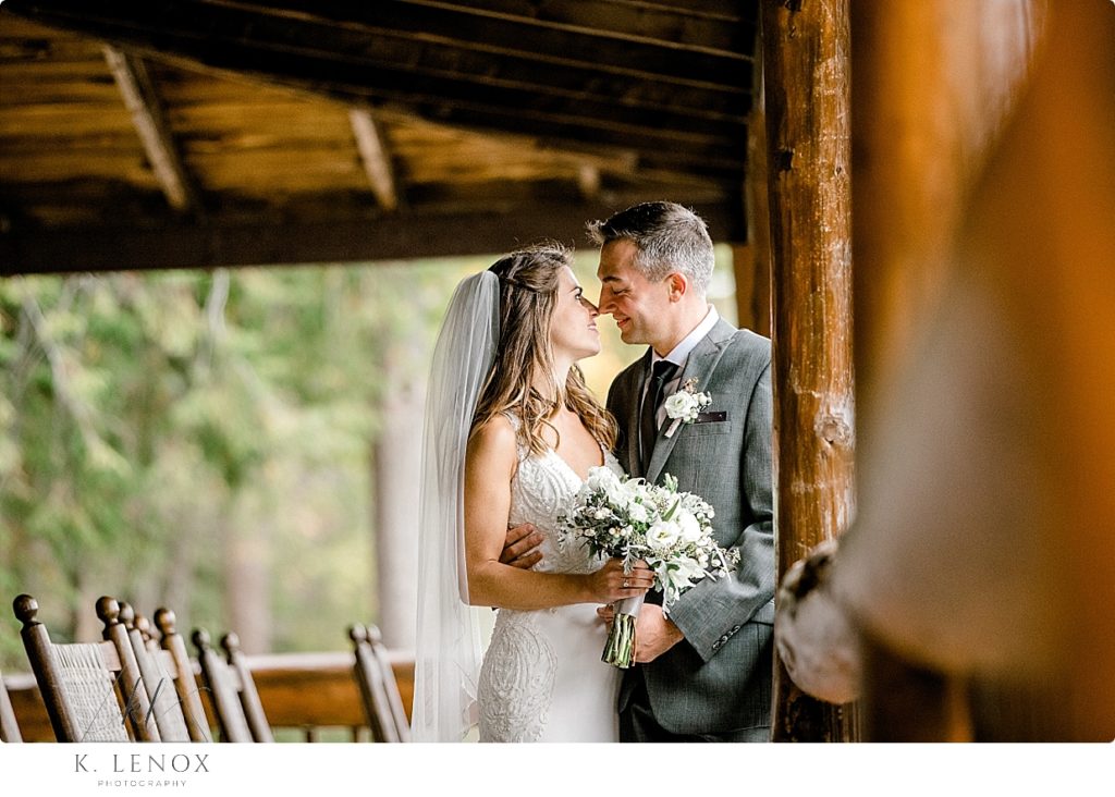 Bride and Groom are nose to nose while on the porch of the lodge at Camp Takodah, just after their wedding. 