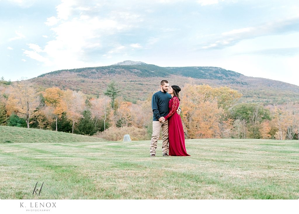 Light and Airy photo of a Man and woman (wearing a red dress) and during Engagement Session at the Grand View Estate with Mount Monadnock in the background. 