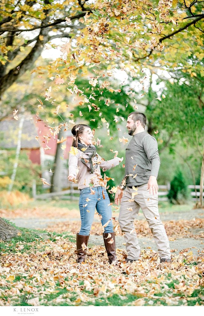 Fall engagement session with a man and woman with leaves falling off the tree over them. Light and Airy Photography by K. Lenox Photography. 
