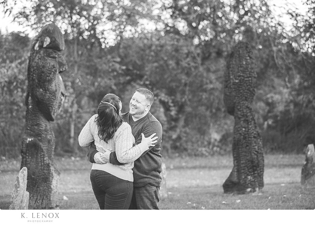 Candid and natural Black and White photo of a man and woman hugging and laughing at the Path of life garden in Windsor Vt. 
