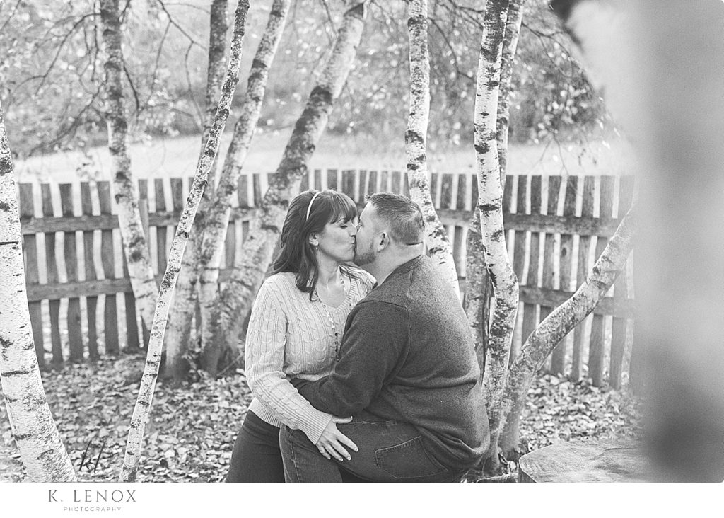Black and white photo of a couple kissing surrounded by birch trees at the Path of Life Garden in NH. 