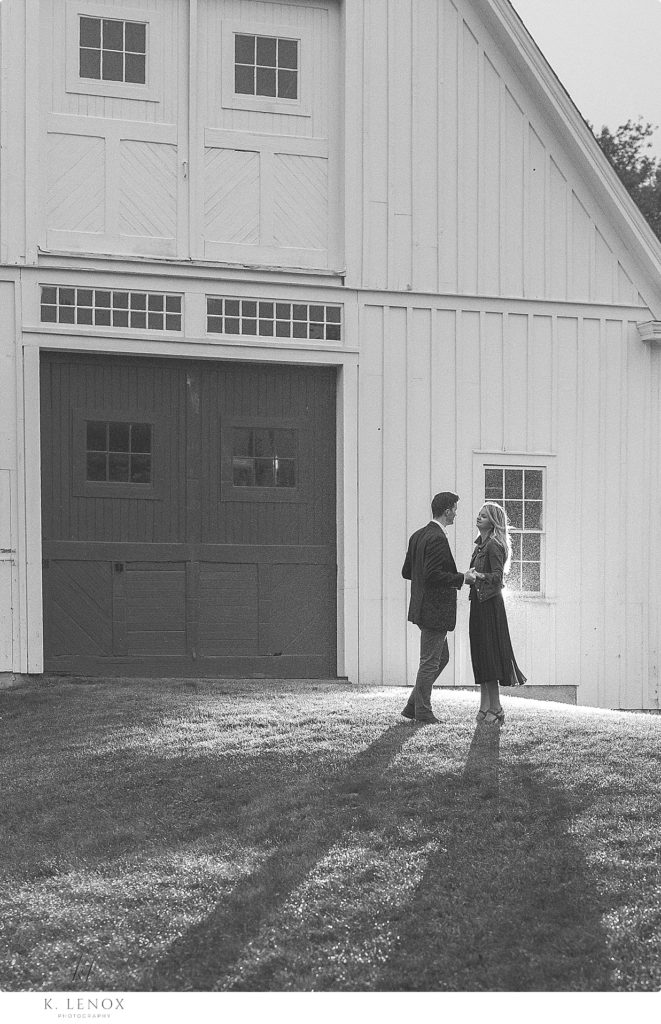 Black and White photo of a man and woman in front of the White Barn at the Scott Farm in VT. 