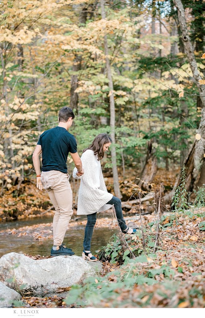 Man and woman walk along the stream in the Fall. 