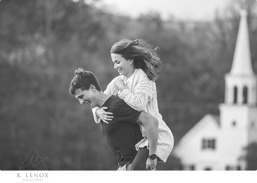Black and White Candid photo of a man and woman playing and giving a piggy back ride. 