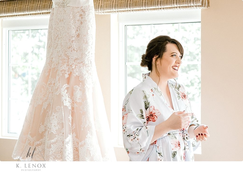 Candid photo of a bride laughing on her wedding day as she gets ready. 