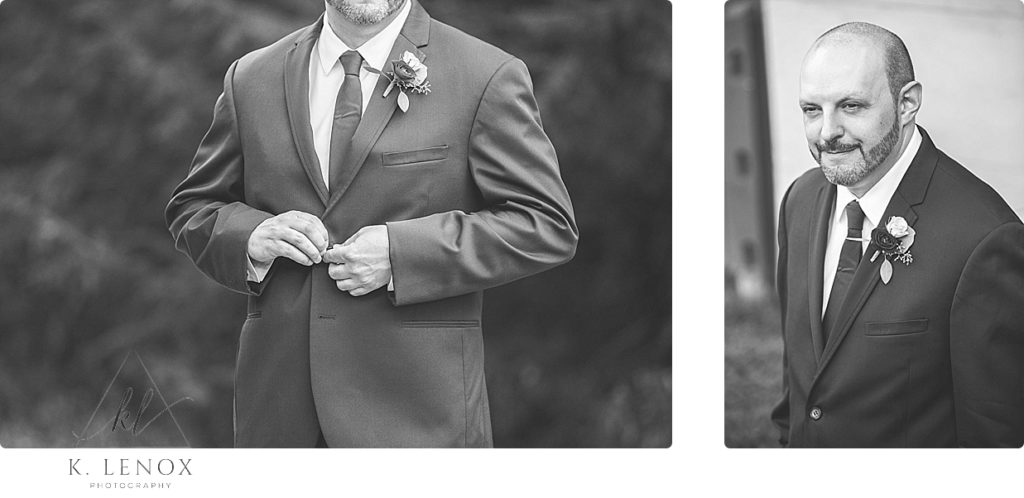Black and white photo of a groom buttoning his suit jacket. 