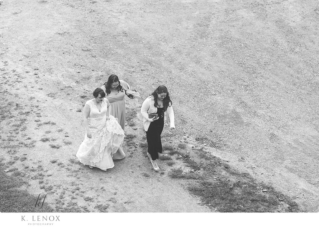 Black and White photo taken from above showing the Bride and her bridesmaids walking into Stonewall farm on the day of her wedding. 