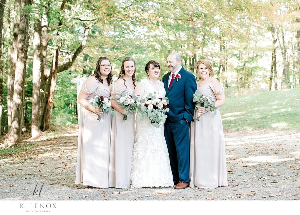 The Groom stands with the bride and Bridesmaids at Stonewall Farm. 