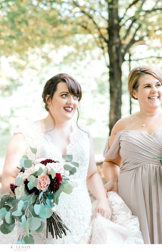 Candid photo of a bride walking with her bridesmaid at Stonewall farm. 