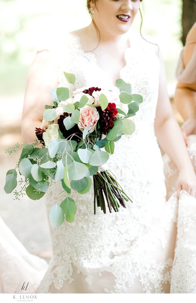 Detail photo of a bride holding her floral bouquet. 