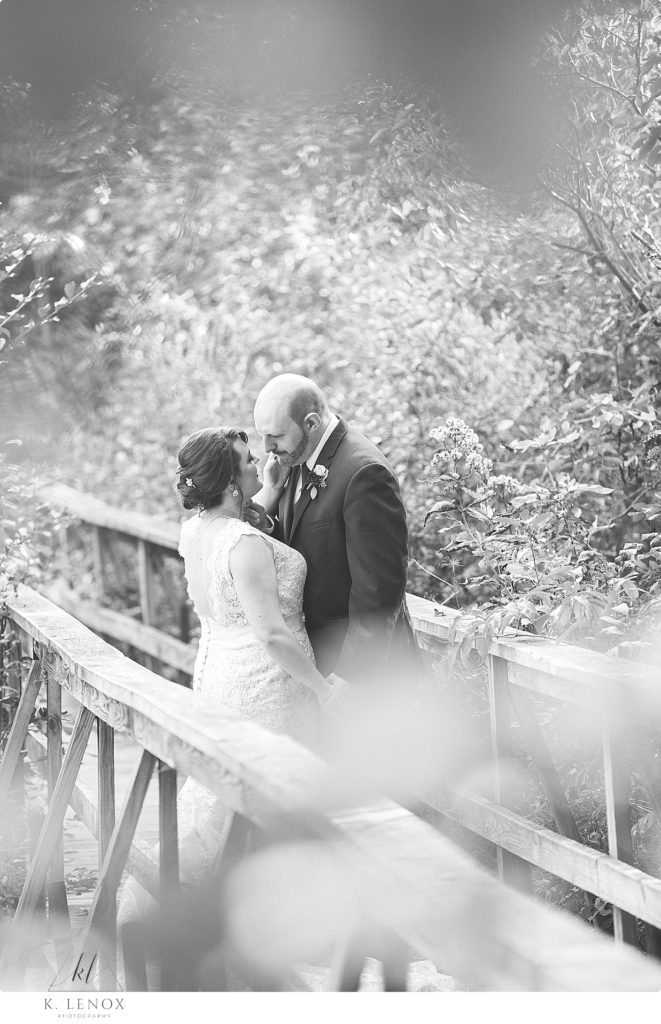 Black and White photo of a bride and groom on a walking bridge at Stonewall Farm. 