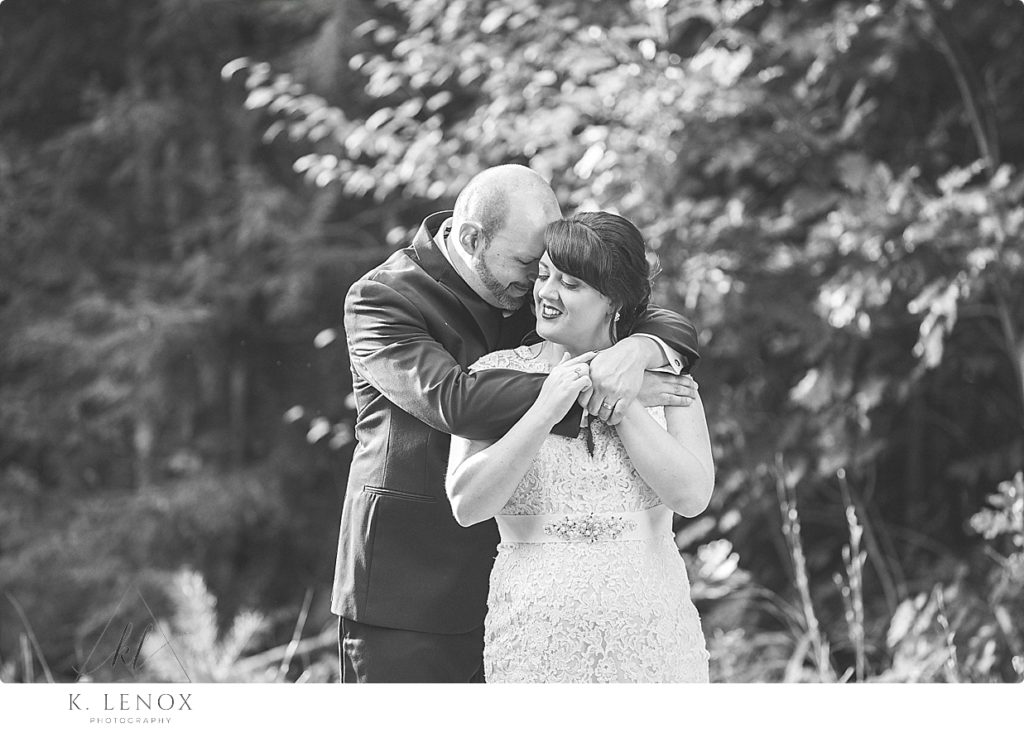 Black and White photo of a bride and groom hugging. 