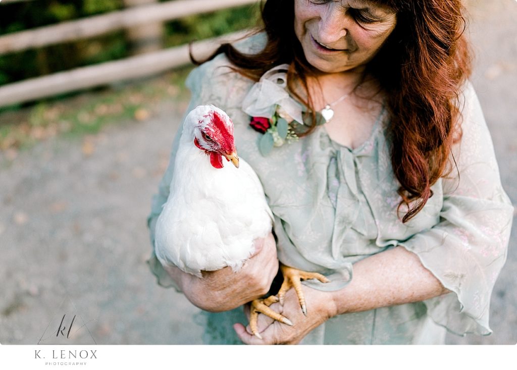 Guest at at wedding at Stonewall Farm picks up the chicken. 
