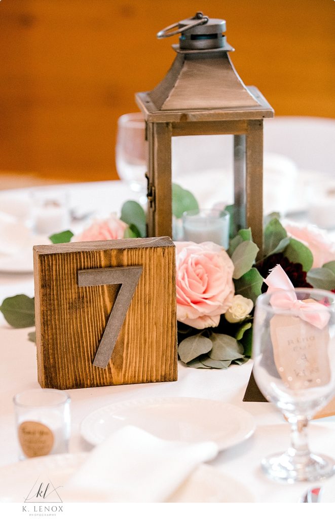 Lantern, Flowers and Wooden table numbers make up the centerpieces for a wedding at Stonewall Farm