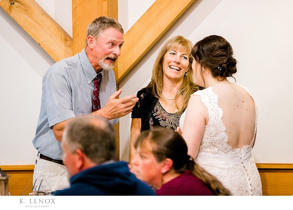 Candid photo of a Bride talking with her guests at a Wedding at Stonewall Farm. 