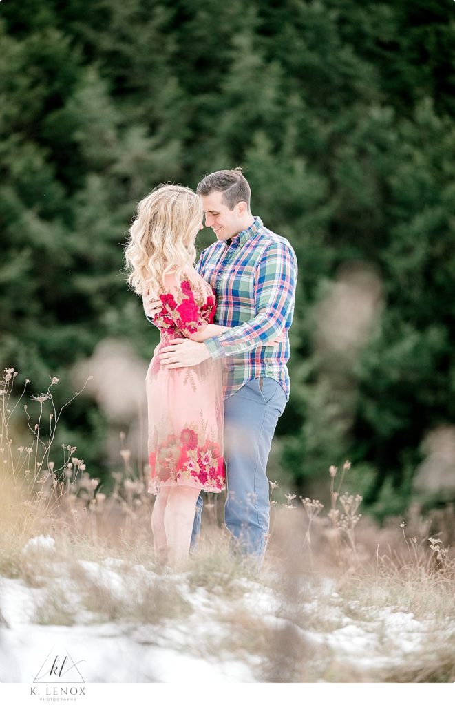 Light & Airy Winter Engagement Session at Stonewall Farm- Man wearing blue tones and girl wearing red dress. 