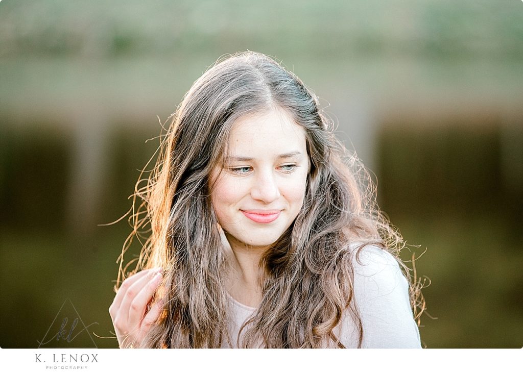 Senior Photo in Chesterfield NH of a girl with long hair backlit by the golden sunlight. 
