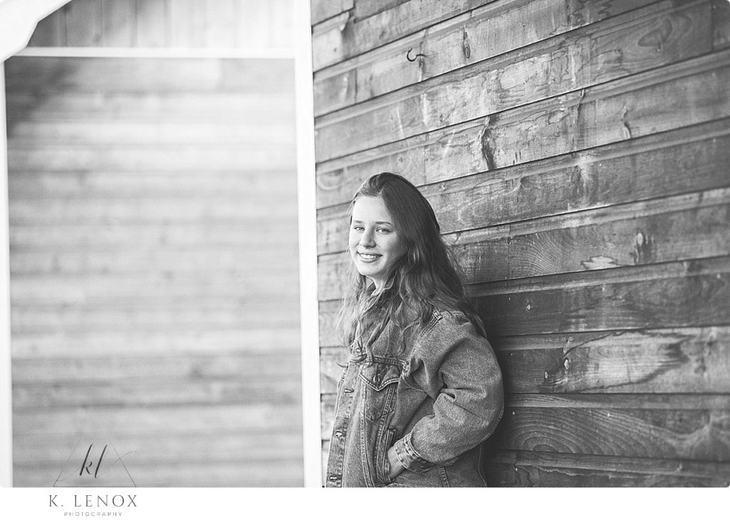 Chesterfield Senior Photos black and white photo showing a girl wearing a vintage Levi's Jean Jacket standing against a wooden wall. 