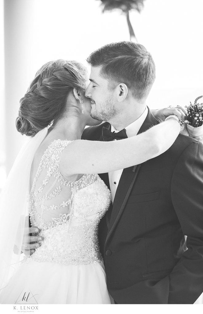 Black and White photo of a Bride and Groom hugging on their wedding day. 
