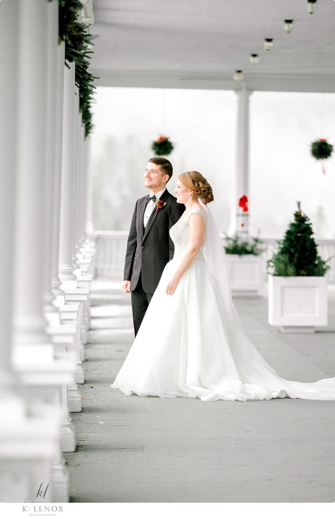 Bride and Groom enjoy the view from the porch of the Omni Mount Washington Resort for their Christmas Wedding. 