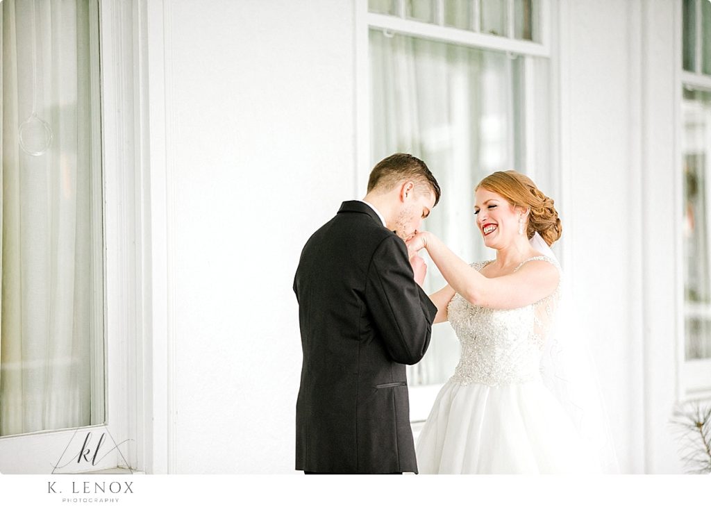 Groom kisses the hands of his bride on their Christmas Wedding Day at the Omni Mount Washington Resort. 