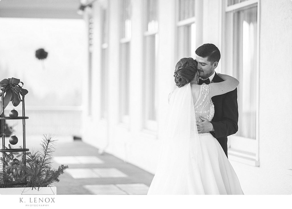 Black and White Photo of a Bride and Groom hugging during their first look for their Christmas Wedding. 