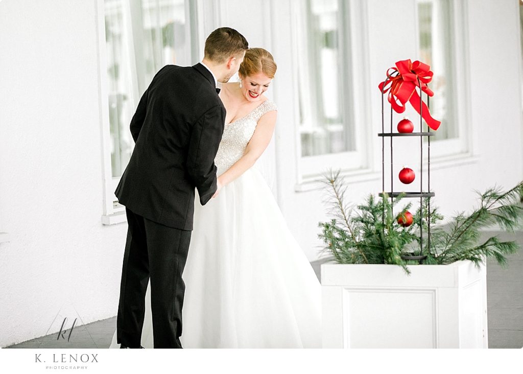 Groom looks at his beautiful red headed bride on their Christmas wedding day. 