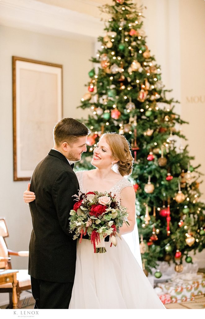 Bride and groom in front of a Christmas Tree in the lobby of the Omni Mount Washington Resort. 
