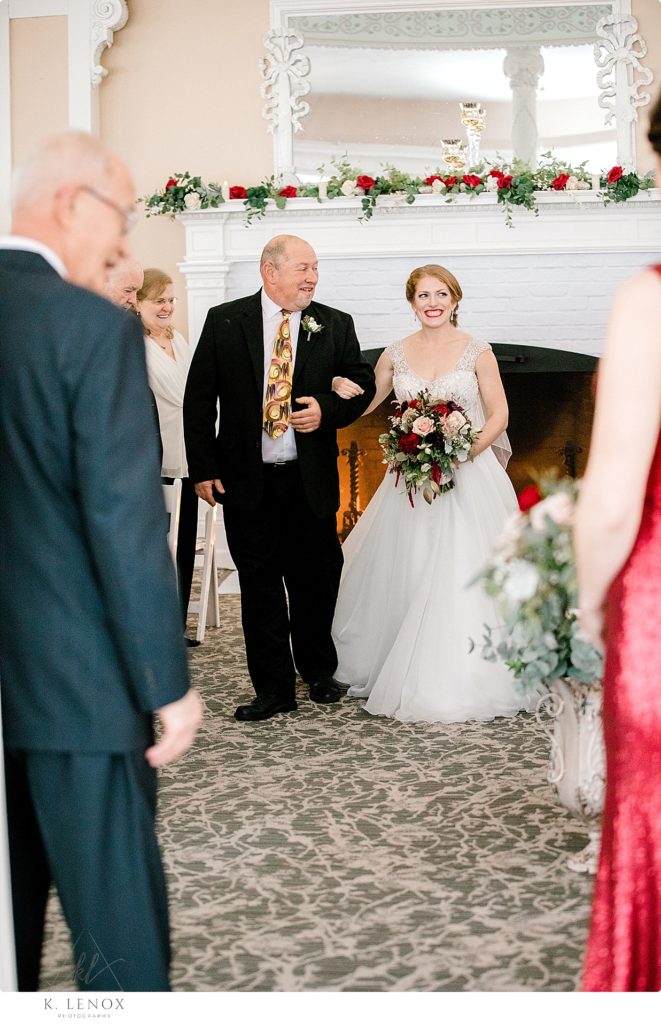 Bride and her Dad walk down the aisle during the Christmas wedding ceremony at the Omni Mount Washington Resort. 