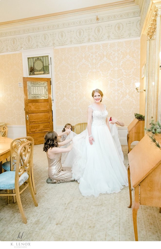 Bride is getting her Wedding Dress Bustled at the Omni Mount Washington Resort. 