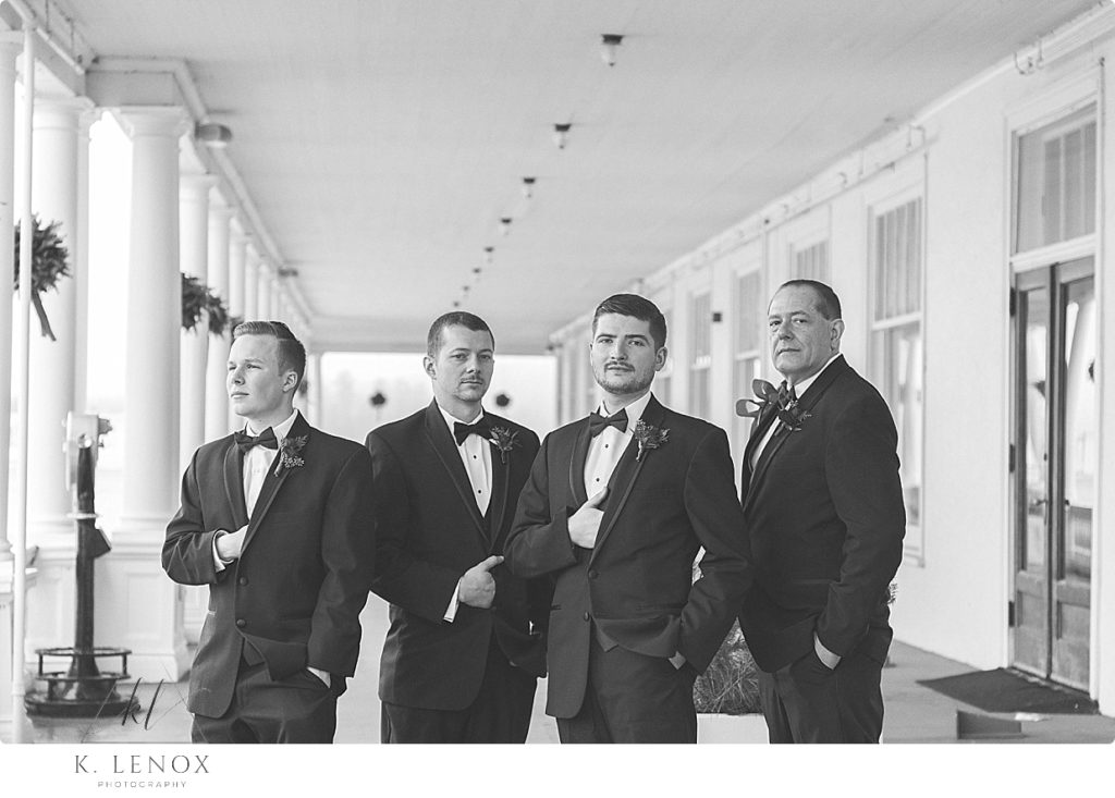 Black and white photo of a groom and three groomsmen wearing tuxedos at the Omni Mount Washington Resort. 