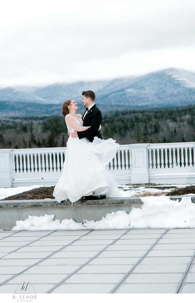 Winter Wedding at the Omni Mount Washington Resort- photo of a bride and groom on the Jewel Terrace at Dusk. Wind Blowing brides gown.