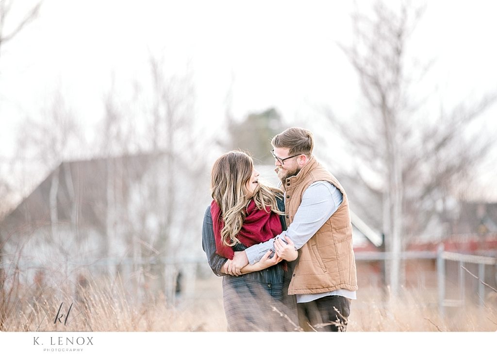 Light and Airy Winter Engagement Photo of a man and woman laughing together. 