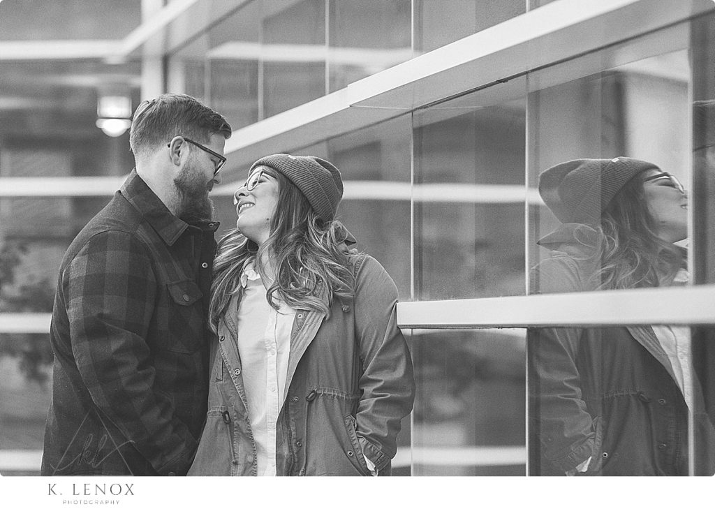 Black and White natural and Candid photo of a man and woman next to a reflective windows. 